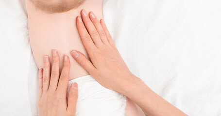 mother's hands stroke the baby's back