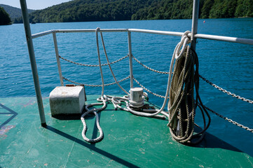 Railing of a boat on a lake with forest
