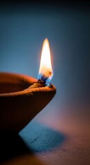 Traditional clay oil lamp with burning flame