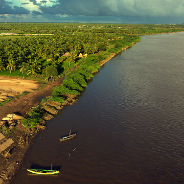 Yanam, India - 02 October 2010: Aerial view of the serene Coringa Wildlife Sanctuary meeting the dark waters of the Godavari River, shadowed by dramatic skies.
