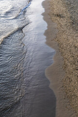 Waves wash the sandy shore of the Mediterranean Sea. Italy