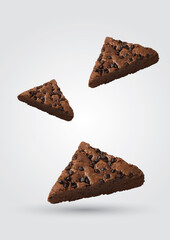 Three Chocolate Drop Brownies of different sizes arranged on a grey background.