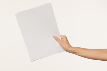 Obraz premium female hand holding a blank sheet of paper