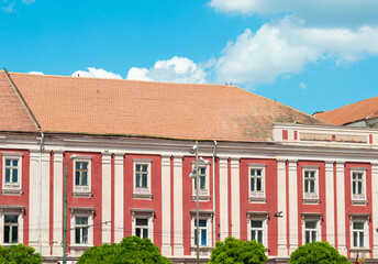 Beautiful historical building in the old town square on a background of blue sky with clouds. Traveling concept  Liberty Square in Timișoara, Romania
