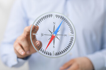 A businessman uses a digital compass, symbolizing strategic planning, direction, and navigation...