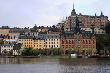 Fototapeta premium Photo with a view of the historic buildings and the waterfront against a cloudy sky early in the morning in central Stockholm, Sweden