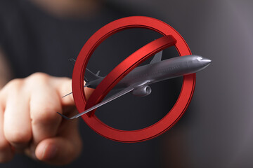 Stock photo of a red no symbol over an airplane, representing travel restrictions or flight...