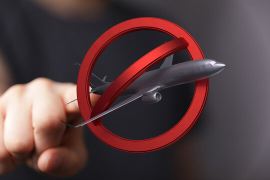 Stock photo of a red no symbol over an airplane, representing travel restrictions or flight cancellations.