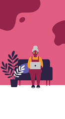 Happy senior woman using a laptop on a sofa at home, showcasing modern connectivity and digital literacy for older adults.