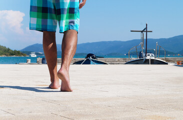 A man walks barefoot in the sun