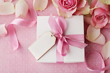 gift box and rose flowers on pink background