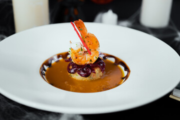 Gourmet Shrimp Dish: A culinary masterpiece featuring a perfectly cooked shrimp, artistically arranged atop a delectable base, presented in a sophisticated setting.