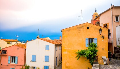 Charming colorful buildings in a french town with tower in the background