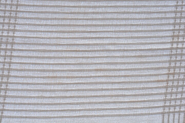 An abstract close-up of a white, fabric curtain with horizontal folds and a visible textile texture