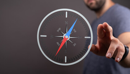 Stock photo of a man using a digital compass, representing navigation, direction, and guidance.