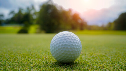 Golf ball is on a green lawn in a beautiful golf course with morning sunshine.