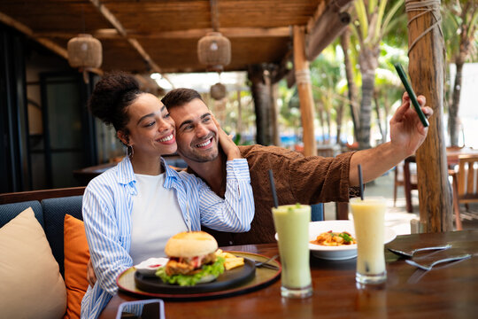 Happy couple shares a moment and a tasty meal at a charming outdoor eatery during their getaway