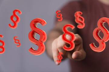 Abstract image of a hand interacting with floating 3D paragraph symbols, representing law, legal,...