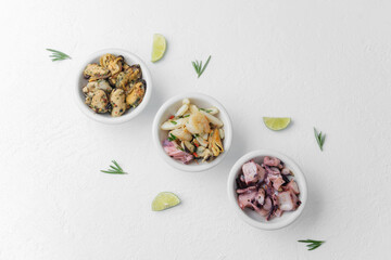 Three seafood bowls with herbs and lime on white background for minimal food composition or diet concept
