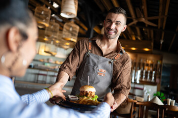 Restaurant marketing moment, a fresh burger and fries served with a smile creates visual content