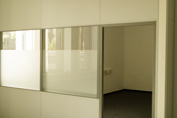 High-quality photo of a modern office partition featuring a sliding glass door. Ideal for...