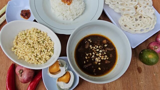 Rawon is Indonesian traditional beef black soup,Original dish from East Java,served with steamed rice,boiled salted duck egg,chili sauce or sambal,bean sprouts and onion crackers