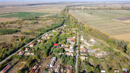 Scenic aerial view of a rural Hungarian village surrounded by farmlands, fields, and greenery. A...