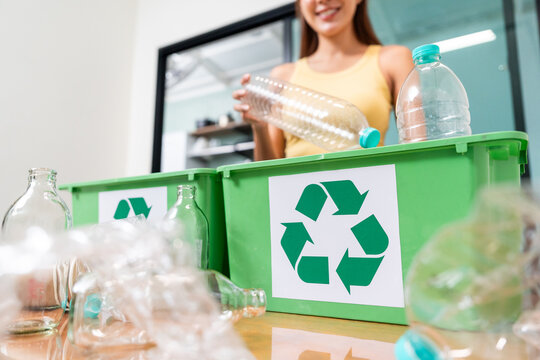 Proud woman separates sorting plastic, paper, and glass at home for recycling. Wife realize sustainable living, waste reduction, and environmental awareness. Female categorize waste concept. - Powered by Adobe