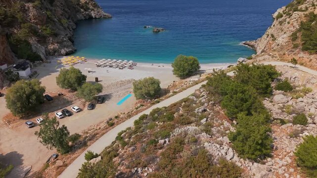 Aerial drone view of Achata sandy beach in Karpathos, Greece, surrounded by rocks and mountains.