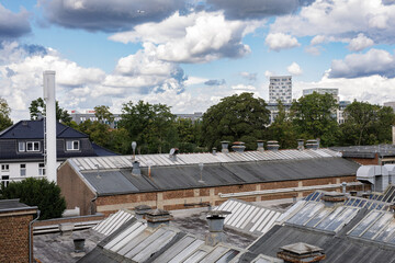 High-angle view of city rooftops, buildings, and a cloudy sky. Perfect for urban, architecture, and industrial themes.