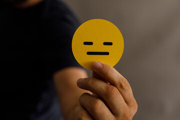 Stock photo of a person holding a yellow circle with a neutral facial expression.  Perfect for...