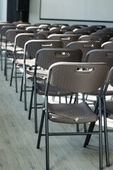 Obraz premium Rows of empty folding chairs arranged in a modern conference room awaiting attendees
