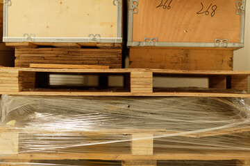 High-quality stock photo of wooden pallets and shipping crates stacked neatly in a warehouse. Ideal...
