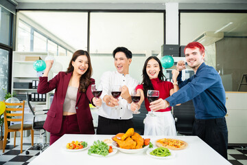 Happy business team raising glasses in celebration around office dinner table, showing corporate culture, team spirit, success, and joyful coworking lifestyle.