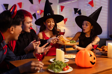 Dinner and group of people celebrating together at Halloween party.