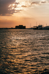 Obraz premium Paphos Castle reflecting on the sea at sunset in Cyprus