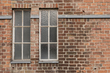 High-resolution image of an old brick wall with two vintage windows. Perfect for backgrounds, textures, and architectural designs.