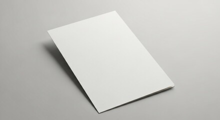 Blank white folded brochure mockup on a gray surface, casting a soft shadow