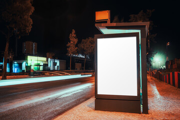 Night cityscape with a glowing blank mockup billboard at a modern bus stop, captured with long exposure showing light trails of passing traffic and urban architecture in vibrant neon hues