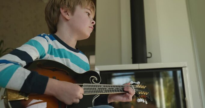 Caucasian Kid Play Mandolin at Home. European Boy Practice Music 4K 10-bit