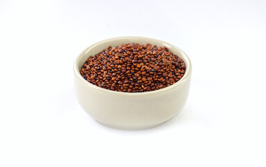 Red quinoa seeds in a bowl on a white background. Quinoa may help control blood sugar levels.