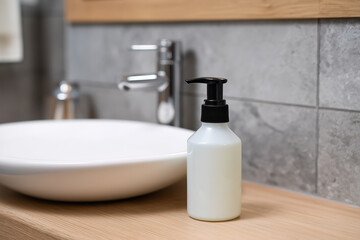 Liquid soap dispenser next to a modern sink and basin