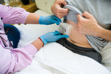 Closeup of hands of doctor changing bandage on patient's wound after surgery