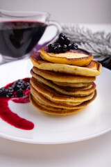 pancakes with blueberry jam in white plate decorated Christmas tree, delicious dessert for breakfast in winter