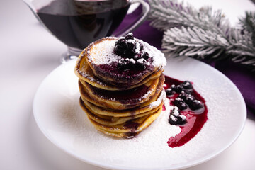 pancakes with blueberry jam in white plate decorated Christmas tree, delicious dessert for breakfast in winter