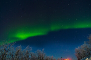Fototapeta premium Northern Lights or Aurora Borealis on a winter night. Vibrant colors shimmer in the starry sky.