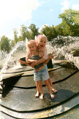 Happy children playing at water fountain outdoors