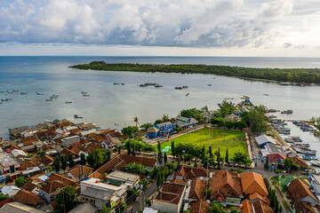 Aerial view of a coastal village with boats and greenery