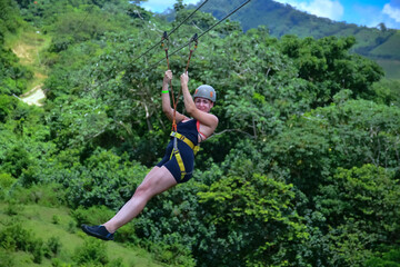 Tourist enjoying zip line adventure in tropical rainforest, punta cana, dominican republic