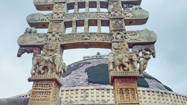 A tilt-up shot unveils the magnificent Sanchi Stupa crowned with its ornate torana. The intricate carvings and towering gateway highlight the grandeur of this UNESCO World Heritage site.